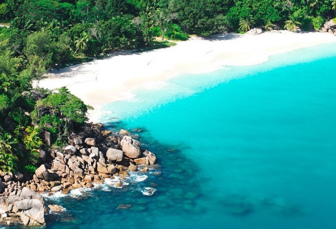 Un paysage de rochers, de sable fin, de végétation luxuriante et de mer dans l’Archipel des Seychelles